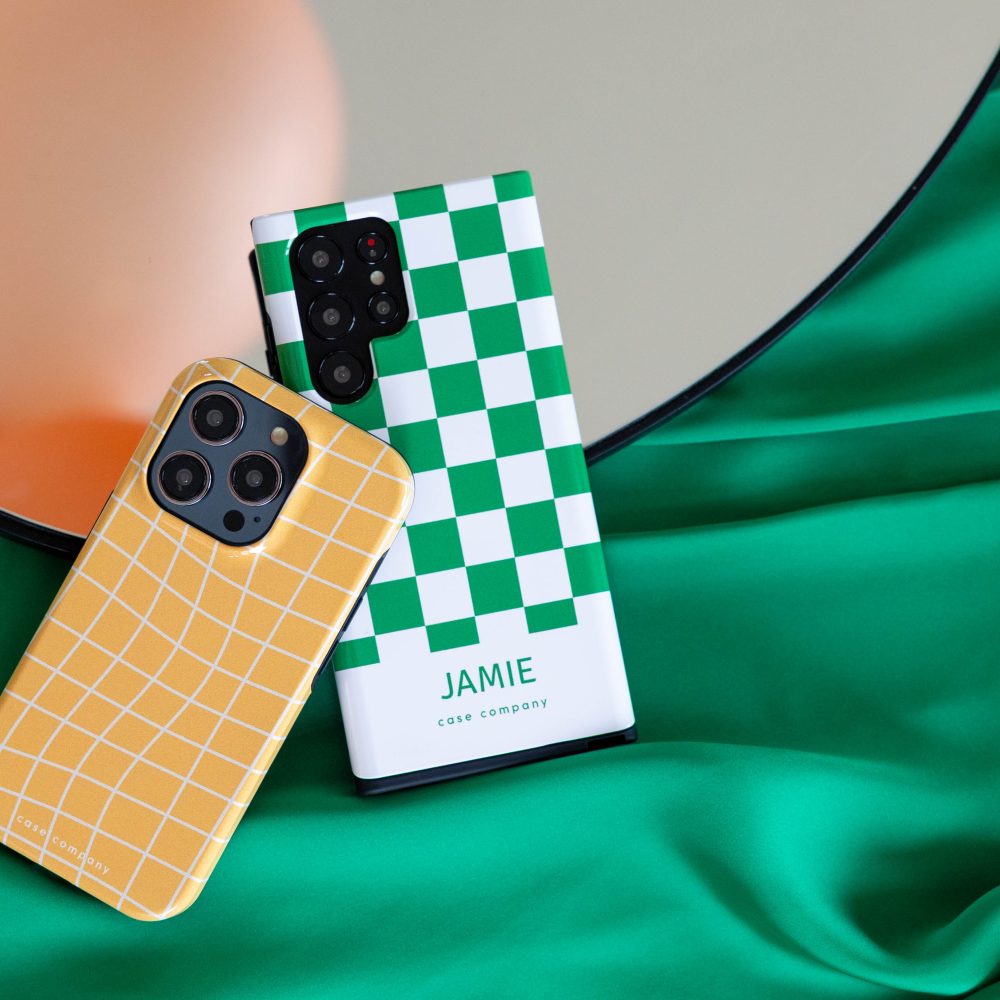 Deux coques renforcées : une jaune à carreaux pour iPhone et une verte à damier avec le nom Jamie